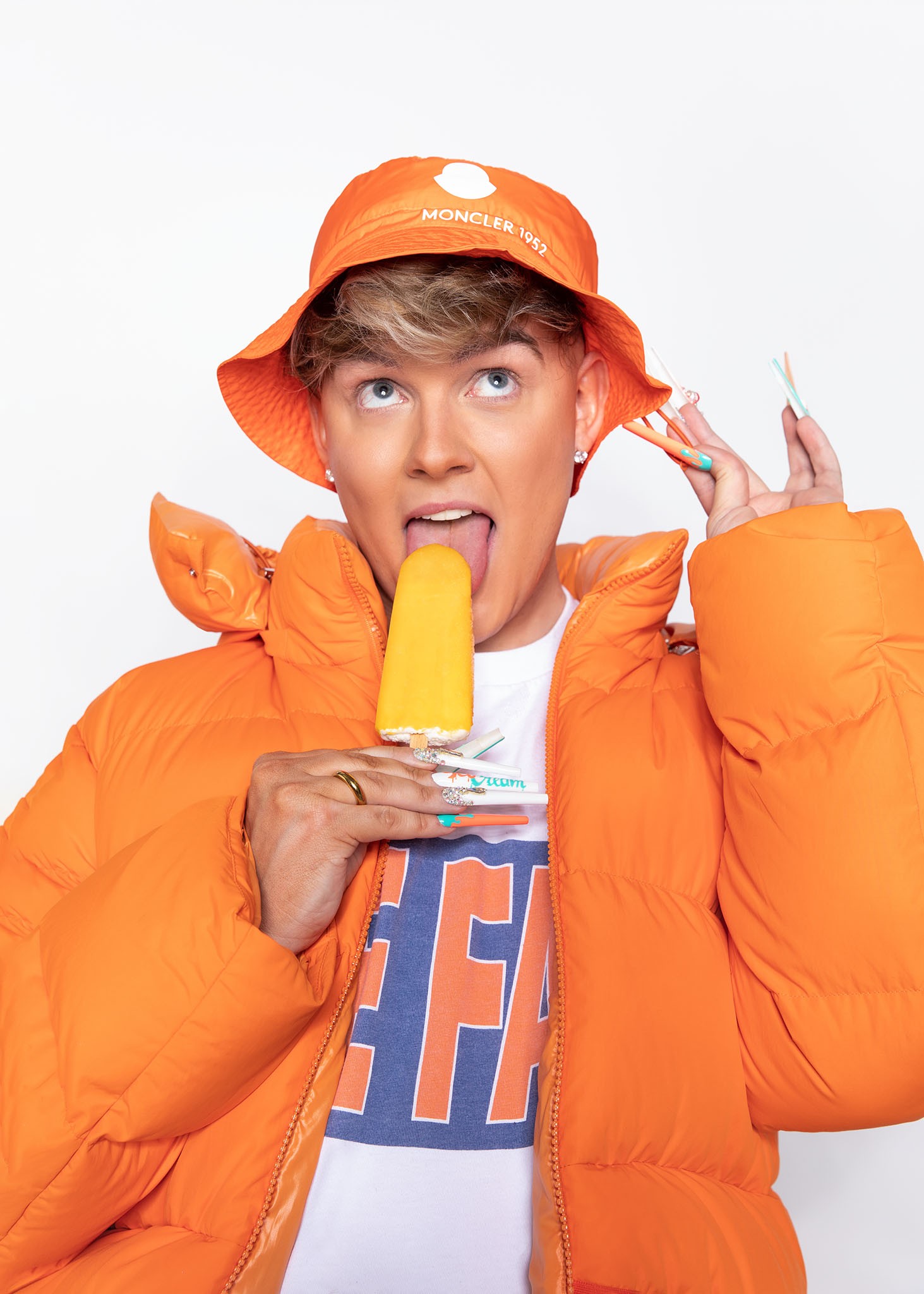 Twenty4Tim mit orangefarbener Jacke und Eis im Fotostudio Helle Kammer Köln